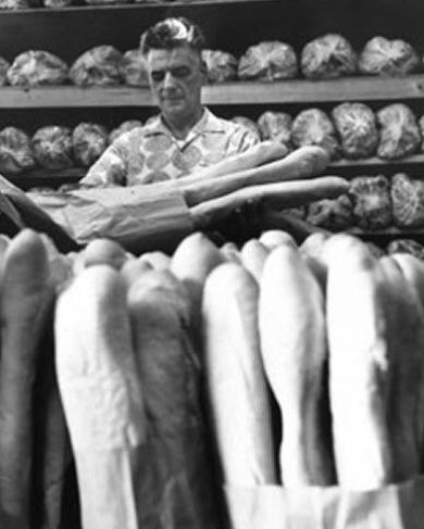 A second-generation Moré baker among rows of fresh Cuban bread at La Segunda.
