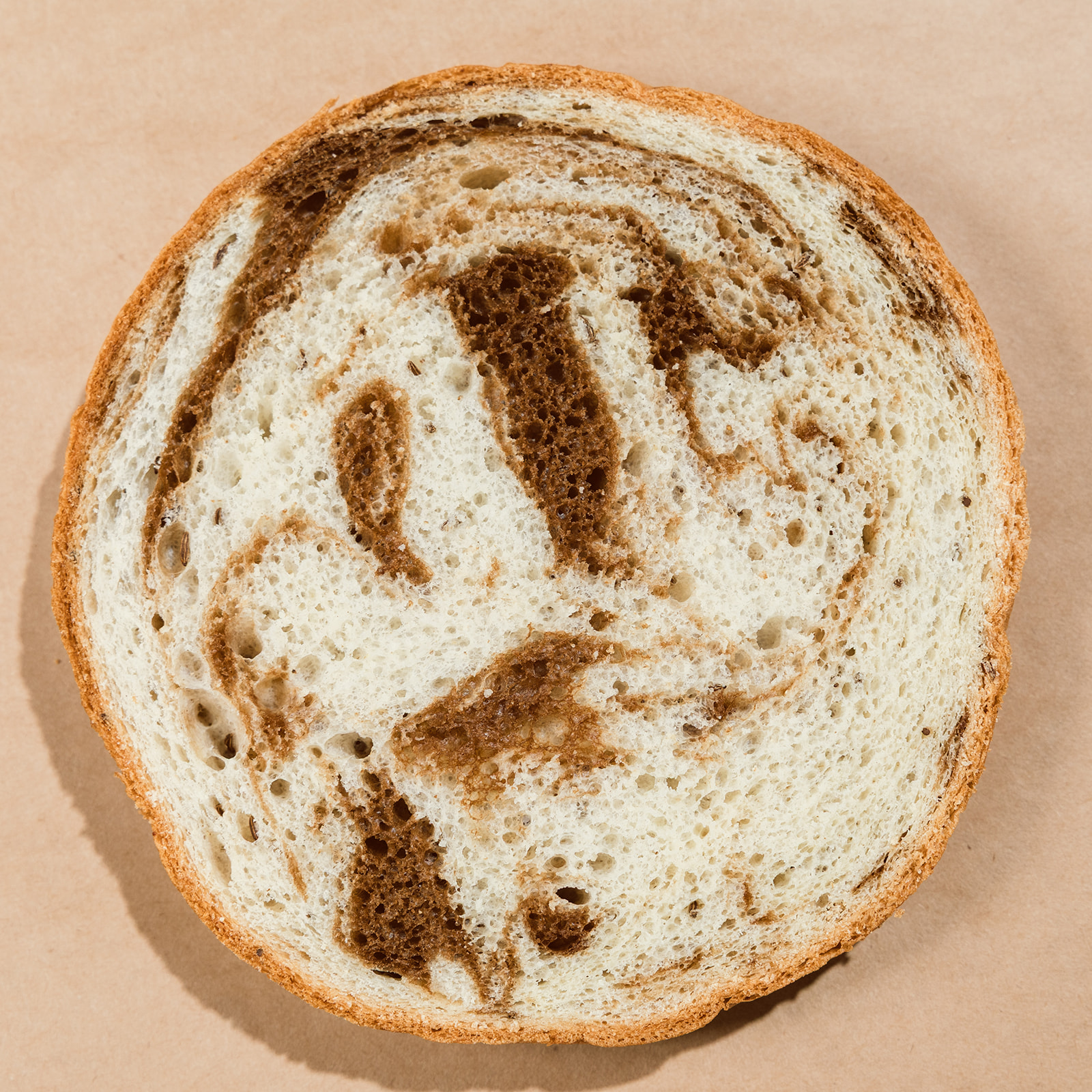 Round cross-section slice of La Segunda marble bucket bread, light and dark rye swirled together.